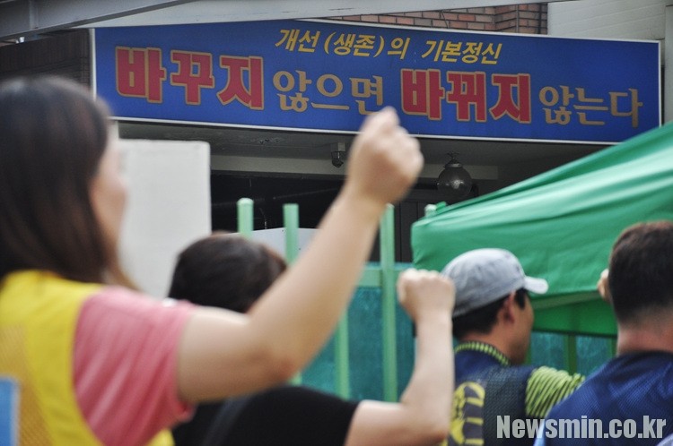 ▲"바꾸지 않으면 바뀌지 않는다" 해단식에 참가자들이 구호를 외치는 사이로 태경산업의 표어가 보인다.